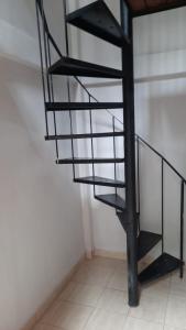 una escalera de caracol negra en una habitación blanca en Tym en Salta