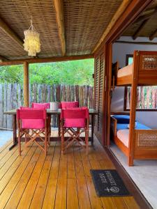 a porch with a table and chairs and a bunk bed at Vulva Caraíva Hostel e Pousada para Mulheres in Caraíva