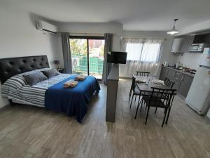 1 dormitorio con cama, mesa y cocina en París 2 Monoambiente en Rosario