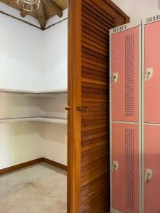 um quarto com um armário e uma porta de madeira em Vulva Caraíva Hostel e Pousada para Mulheres em Caraíva