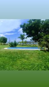 uma piscina num parque com árvores e relva em Luz de Luna Ubicación privilegiada frente a laguna y piscina em San Cosme