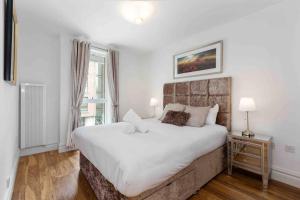a bedroom with a large white bed and a window at Waterfront Luxury in Dublin