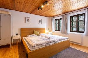 ein Schlafzimmer mit einem großen Bett und einer Holzdecke in der Unterkunft Chata u Židle in Boží Dar