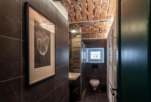 a bathroom with a toilet and a picture on the wall at Chata u Židle in Boží Dar