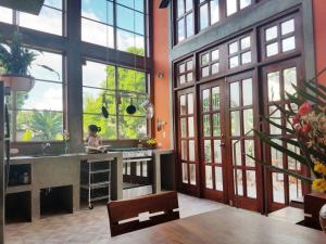 グラナダにあるSecret Cottage Granada Nicaraguaの大きな窓とシンク付きの広いキッチンが備わります。