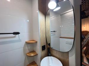 Łazienka z lustrem i białą toaletą w obiekcie Chic4 luxury Gran via w Madrycie