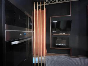 kuchnia z czarnymi szafkami i telewizorem na ścianie w obiekcie Chic4 luxury Gran via w Madrycie +10 zdjęć