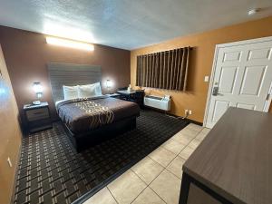 Piccola camera d'albergo con letto e scrivania. di New Corral Motel a Victorville
