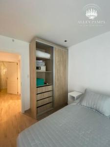 - une chambre blanche avec un lit et un placard dans l'établissement Alley Pampa, à Mar de las Pampas
