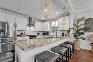 a kitchen with white cabinets and a counter with stools at Modern 3-bedroom home with patio and fire pit in Memphis