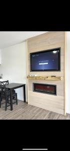 een woonkamer met een flatscreen-tv en een tafel bij Downtown Inn in Rochester