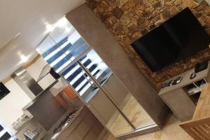 a kitchen with a stainless steel refrigerator and a tv at 5 star Smart studio 30m2 in Flic-en-Flac