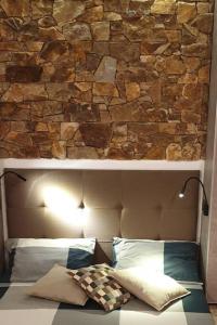 a stone wall above a bed with two pillows at 5 star Smart studio 30m2 in Flic-en-Flac