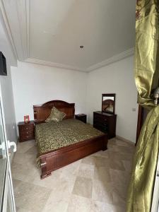 - une chambre avec un lit en bois et 2 tables de chevet dans l'établissement Appart " Haut Standing Marοcain " 120m2 city center, à Tanger