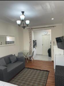 a living room with a couch and a table at Tia Maria cottage in Cape Town