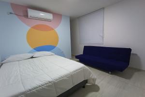 a bedroom with a bed and a blue chair at Ayenda Brisas del Rio in Barranquilla