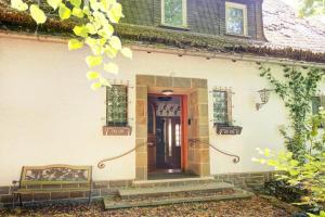 uma casa com uma porta e um banco à frente dela em Jagdreich im Westerwald 