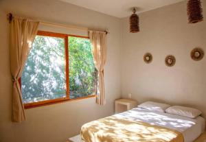 a bedroom with a bed and a window at Casa Lunada in Holbox Island