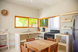 eine Küche mit einem Holztisch und einem Kühlschrank in der Unterkunft Casa Lunada in Holbox