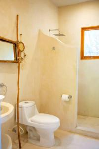 a bathroom with a white toilet and a shower at Casa Lunada in Holbox Island