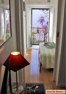 リスボンにあるCasa Da Severa Apartmentsのベッドと窓が備わる客室です。