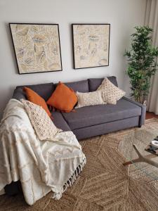 niebieska kanapa z poduszkami w salonie w obiekcie Cristinas 2 Bedroom Apartment Caniço w Caniço
