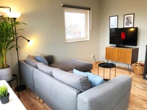 a living room with a couch and a tv at LIME HOMES: Balkon, Küche, Netflix in Barsinghausen