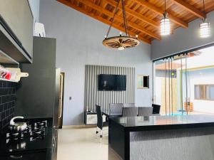 a kitchen with a black counter top and a living room at Casa Privativa na Av. Garibaldi Vila A in Foz do Iguaçu