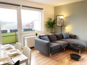 a living room with a couch and a large window at LIME HOMES: Balkon, Küche, Netflix in Barsinghausen