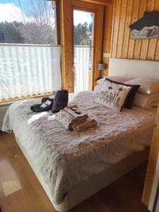 een slaapkamer met een groot bed en een raam bij Confortable Chalet pie des pistes Pyrénées 2000 in Bolquere Pyrenees 2000