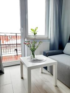 una sala de estar con una mesa blanca con flores. en Na wzgórzu en Wieliczka