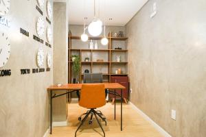 an office with a desk and a chair and clocks at ZEE Studios by Viva - Studios a 200m da beira-mar norte in Florianópolis