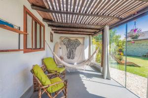 un porche con 2 sillas y una hamaca en Casa Natureza Praia do Rosa, en Imbituba