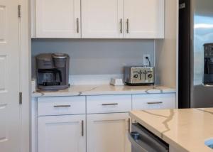 une cuisine avec des placards blancs et un comptoir avec un four micro-ondes dans l'établissement Cozy Sweet Retreat Brand New Private Home w Spa Game Room and Firepit, à Washington