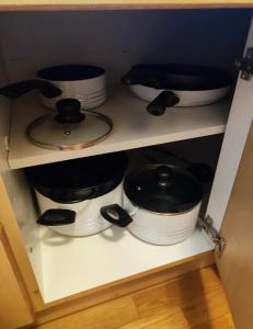 a shelf with several pots and pans on it at Apartment inklusive Parkplatz in Velden am Wörthersee