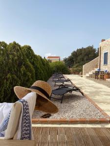 a person sitting on a bench with a hat at Marina Castellana Studios in Halki