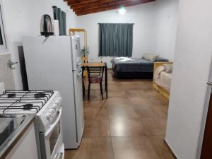 a kitchen with a stove and a refrigerator and a bed at El Sauce in Los Cocos