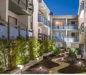 een binnenplaats van een appartementencomplex met een tuin bij Charming Hollywood Condo with Pool & Balcony in Los Angeles