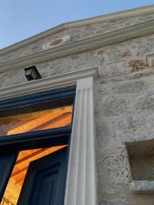 a building with a column next to a door at Marina Castellana Studios in Halki