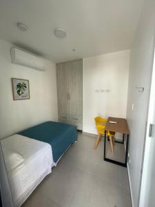 ein kleines Schlafzimmer mit einem Bett und einem Schreibtisch in der Unterkunft 2br aptSurrounded by history with Modern Amenities in Panama-Stadt