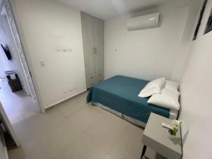 Kleines weißes Zimmer mit einem Bett und einem Tisch in der Unterkunft 2br aptSurrounded by history with Modern Amenities in Panama-Stadt