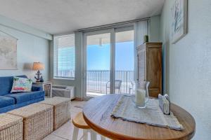 a living room with a blue couch and a table at The Ocean Calls, Unit #612 in Daytona Beach