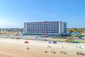 a beach with a large building in the background at The Ocean Calls, Unit #612 in Daytona Beach