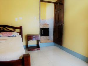 a bedroom with a bed and an open door to a bathroom at Hospedaje Siero in Moyogalpa