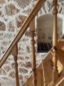 a wooden spiral staircase with a stone wall at Marina Castellana Studios in Halki