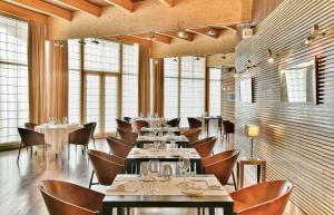 a dining room with tables and chairs and windows at NH Collection Palacio de Burgos in Burgos