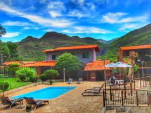 a resort with a pool and mountains in the background at Pousada Mandalla in Serra do Cipo