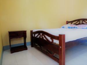 a bedroom with a wooden bed and a night stand at Hospedaje Siero in Moyogalpa