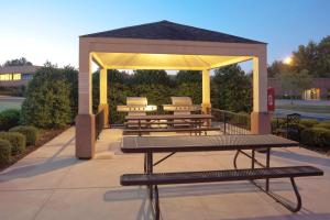 a gazebo with benches and a picnic table at Sonesta Simply Suites Plano Frisco in Plano