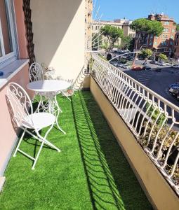 balcón con mesa, sillas y césped en RomAntic Dreams Guest House, en Roma